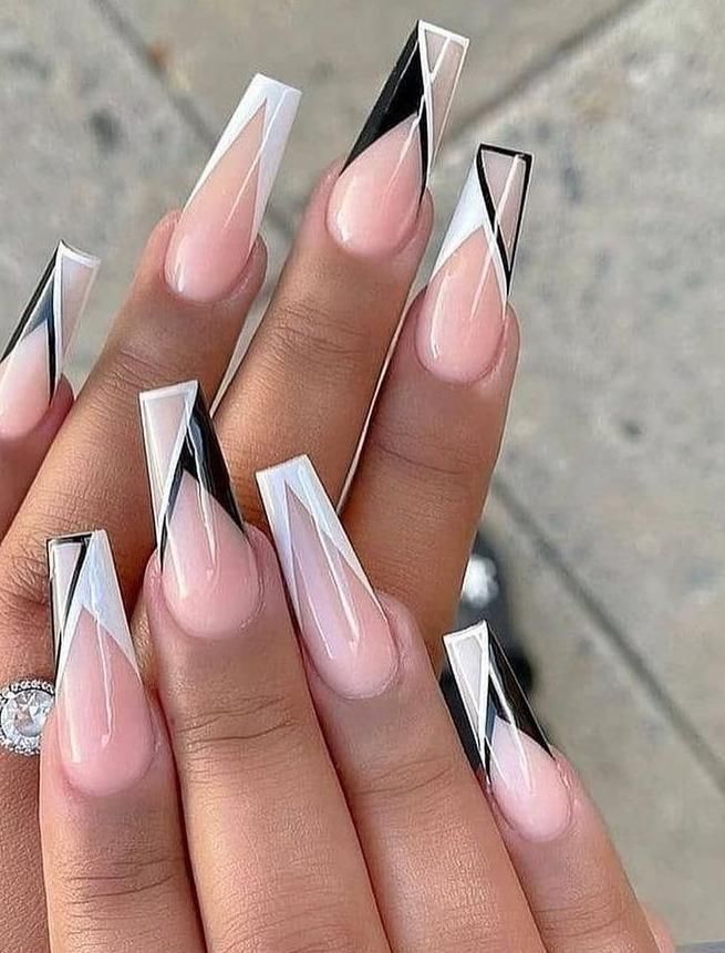 Unhas geométricas em preto e branco com efeito triângulo nas pontas, estilo moderno e ousado