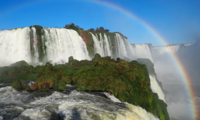 Vista das Cataratas do IguaƧu com arco-Ćris ao fundo, uma das Sete Maravilhas Naturais do Mundo.