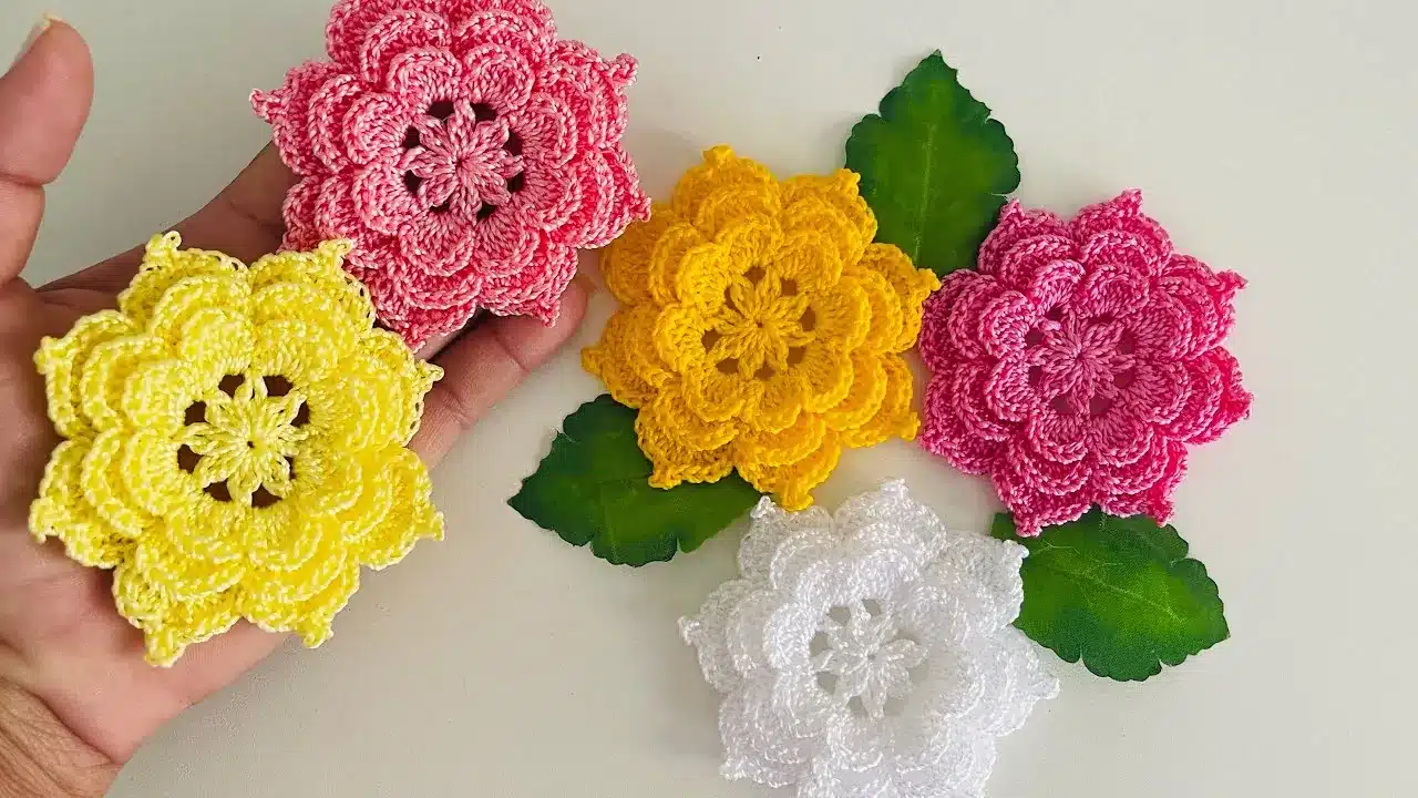 Flores coloridas de crochê com folhas verdes para aplicação artesanal