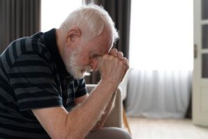 Homem idoso demonstrando sinais de confusão, um dos sintomas precoces do Alzheimer, com foco nas dificuldades cognitivas.