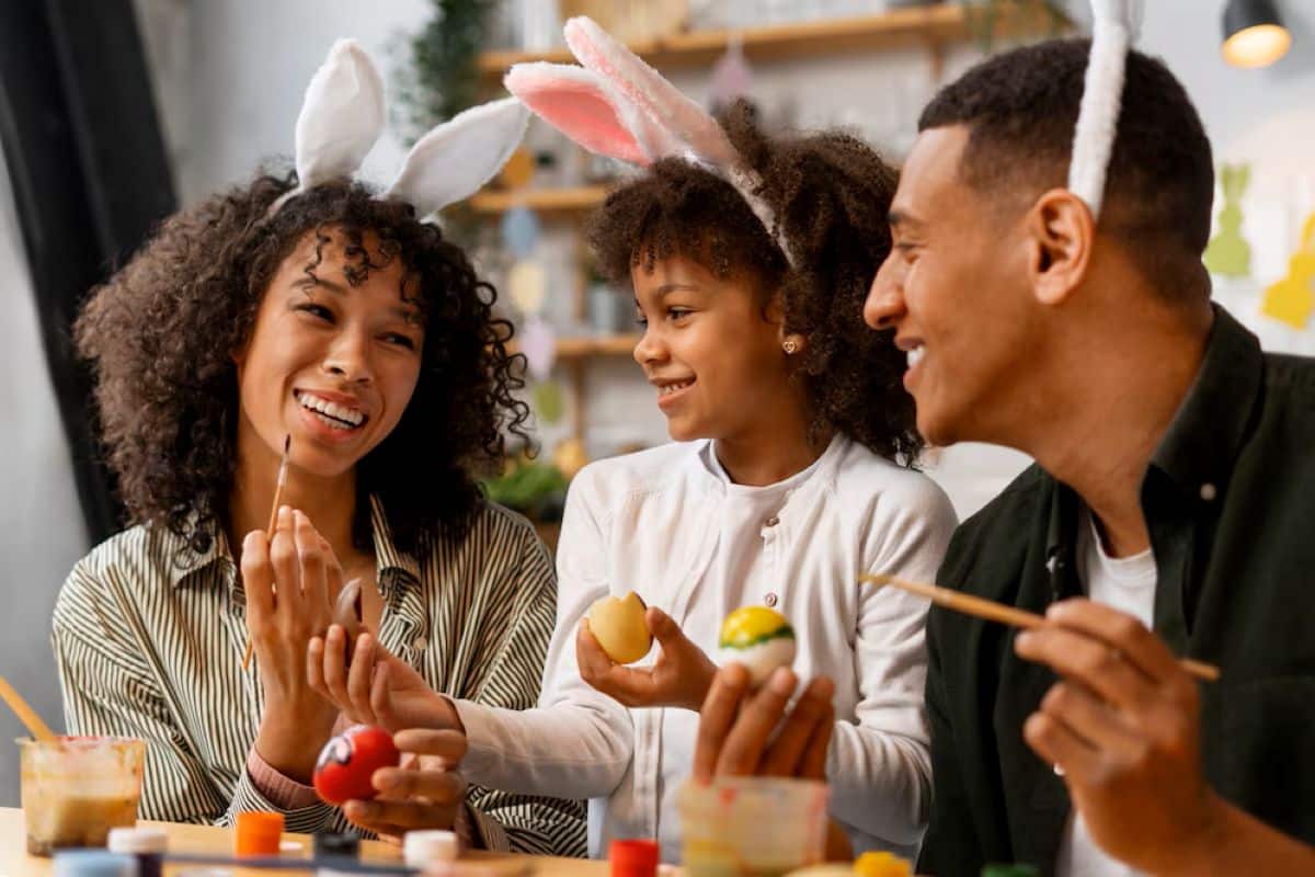 Família celebrando a Páscoa, com crianças pintando ovos de Páscoa, simbolizando momentos de união e celebração com receitas sem carne.