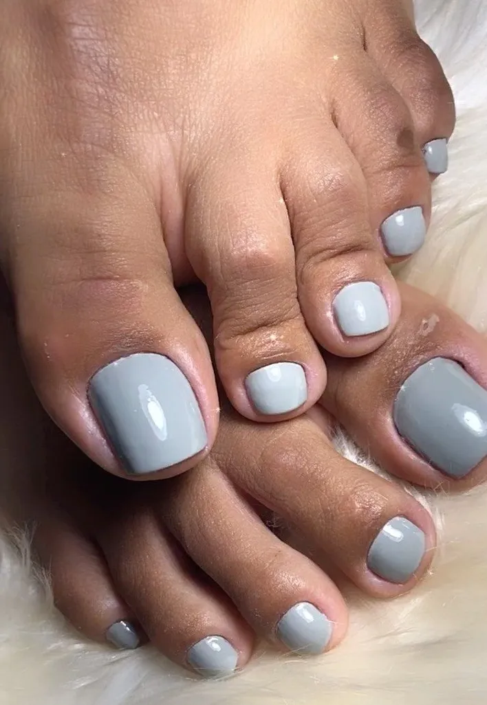 Unhas dos pés com esmalte cinza claro, estilo moderno e discreto