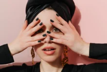 Mulher com turbante e unhas negras, inspirada no estilo de Lady Gaga para o show no Brasil.