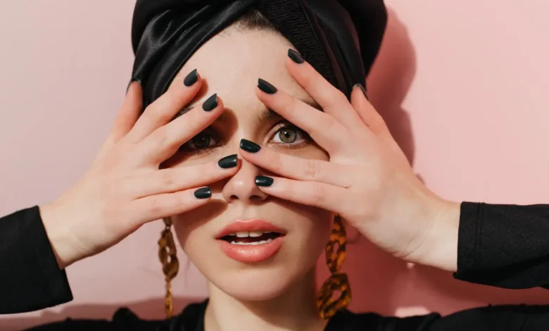 Mulher com turbante e unhas negras, inspirada no estilo de Lady Gaga para o show no Brasil.