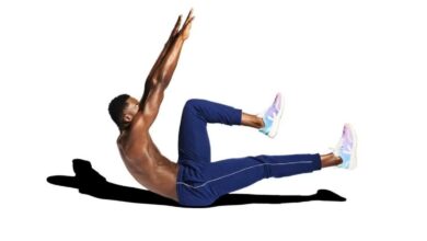 Homem fazendo exercício abdominal no chão, com pernas e braços elevados.