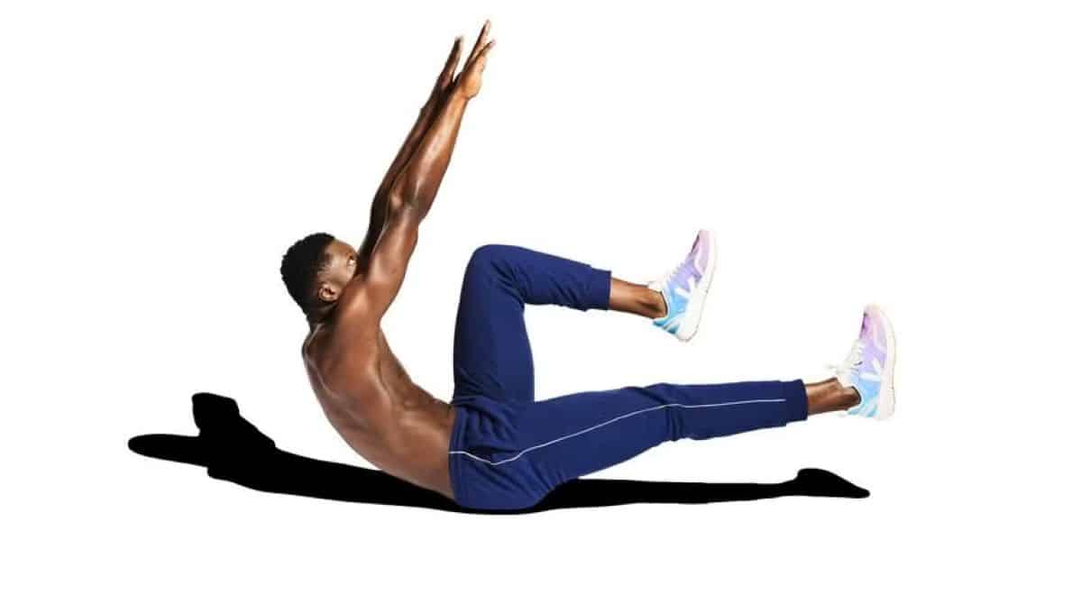 Homem fazendo exercício abdominal no chão, com pernas e braços elevados.