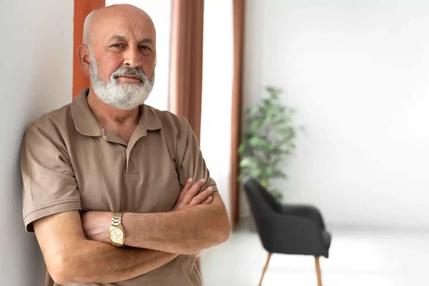 Idoso de braços cruzados, olhando para a câmera com um semblante sério, em um ambiente interno moderno e bem iluminado, simbolizando a reflexão sobre a aposentadoria