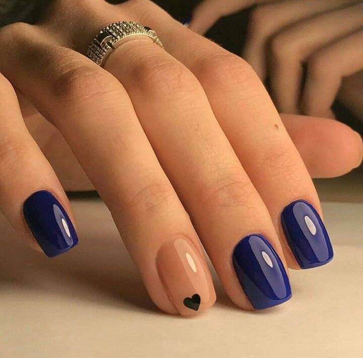 Unhas pintadas com esmalte azul oceano e detalhe em nude com coração preto