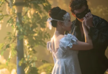 Cena romântica de baile de máscaras com um casal em trajes de época na série Bridgerton.