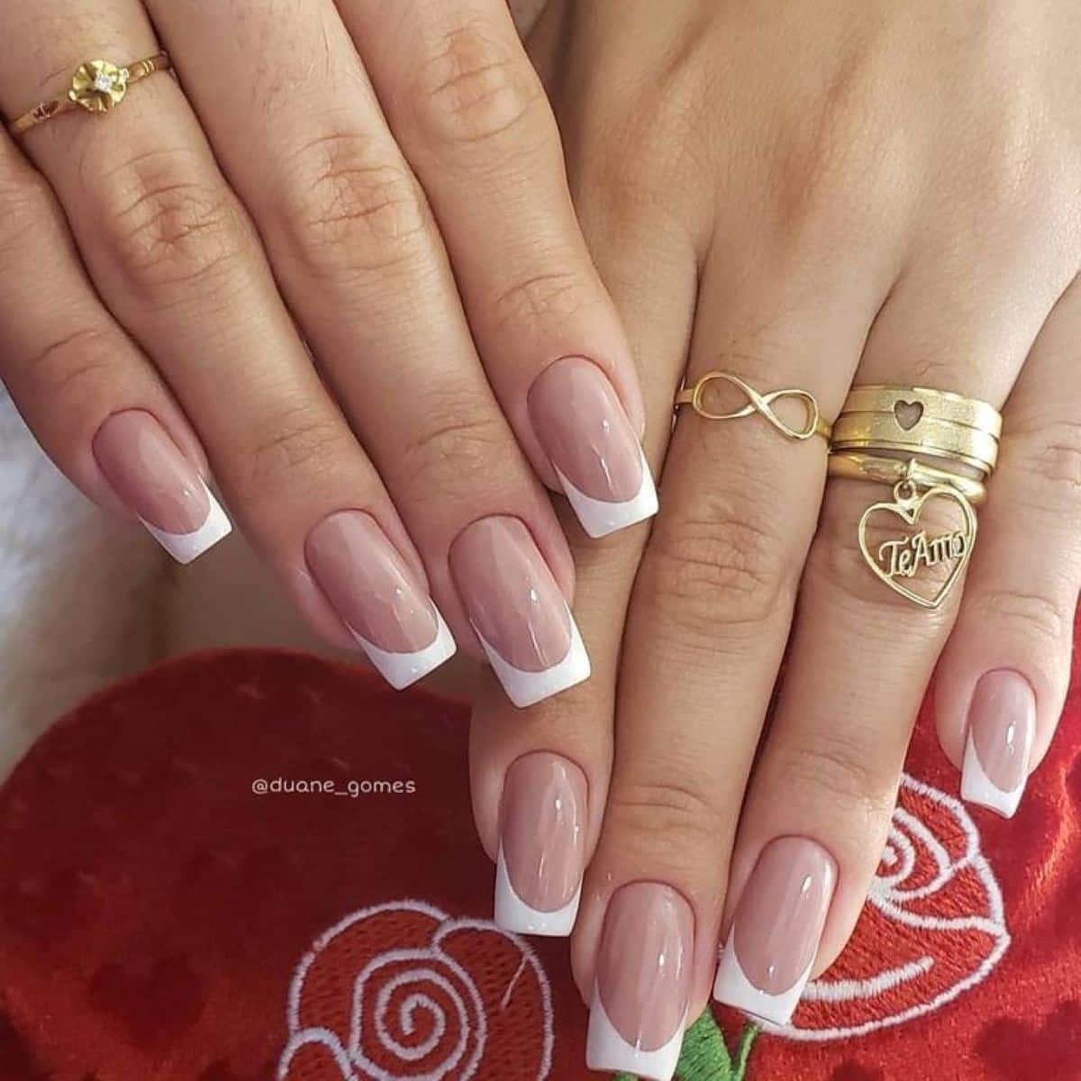 Unhas com francesinha clássica em branco, em formato quadrado e base nude.