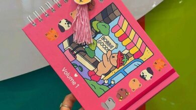 Livro de colorir Bobbie Goods Volume 1 com capa rosa, ilustração de ursinho e enfeite de pompom