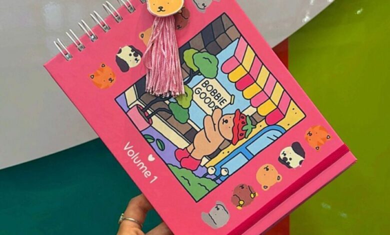 Livro de colorir Bobbie Goods Volume 1 com capa rosa, ilustração de ursinho e enfeite de pompom