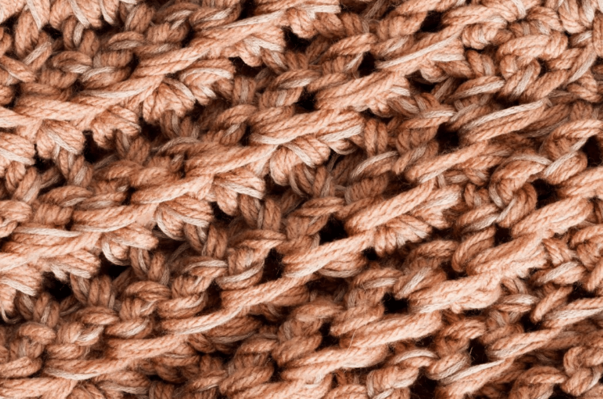 Detalhe de crochê em tons terrosos, destacando a textura e a cor Mocha Mousse.