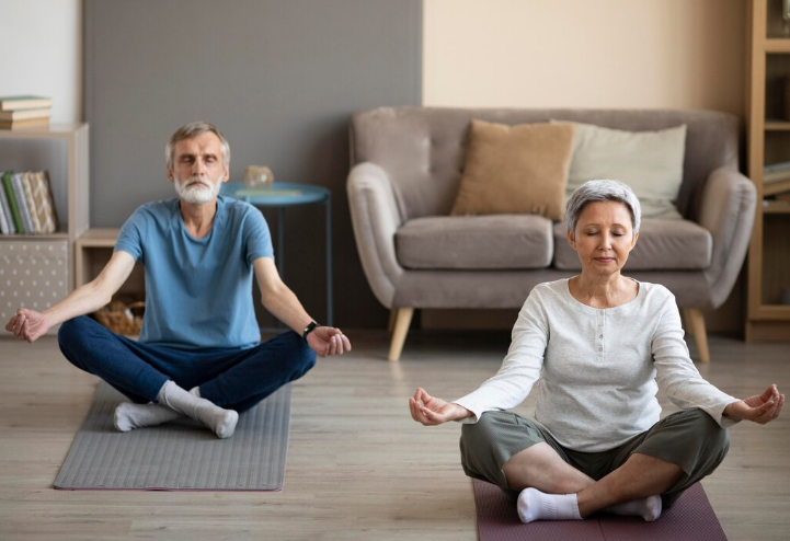 Casal maduro praticando yoga e meditação em casa