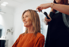 Mulher sorrindo enquanto recebe penteado no salão, corte Riviera Bob em destaque, simbolizando a tendência de cabelo em 2025.