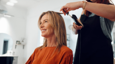Mulher sorrindo enquanto recebe penteado no salão, corte Riviera Bob em destaque, simbolizando a tendência de cabelo em 2025.