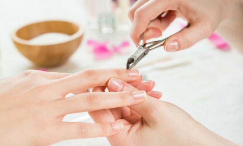 Pessoa realizando cuidado delicado das unhas com alicate para cutículas