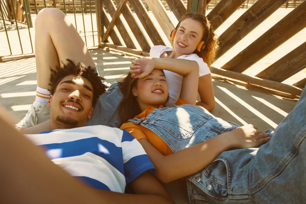 Jovens relaxando ao sol, sorrindo e aproveitando o tempo livre durante um feriado