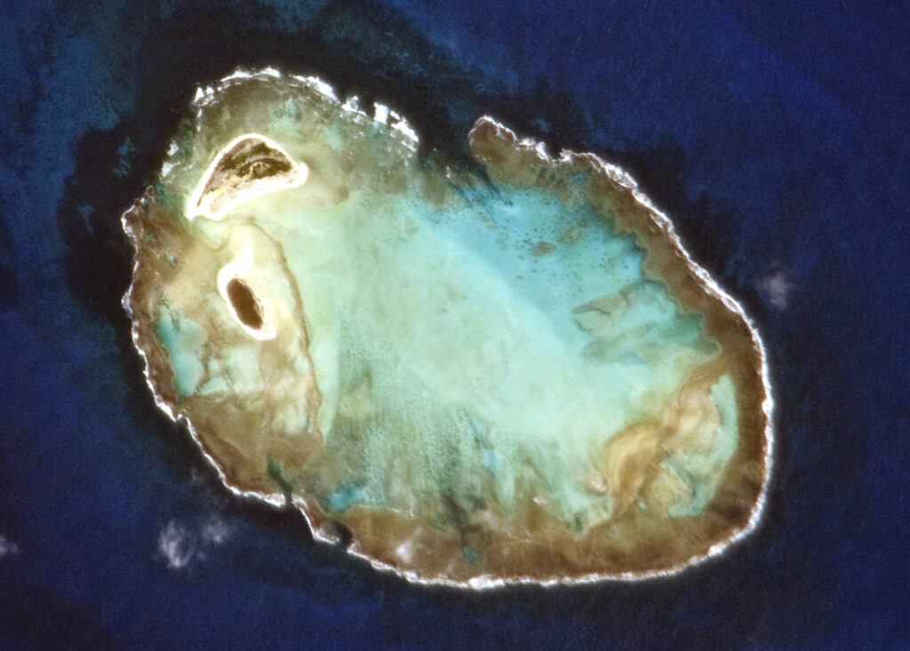 Vista aérea do Atol das Rocas, uma área de proteção ambiental no Brasil, com águas cristalinas e rica biodiversidade marinha.