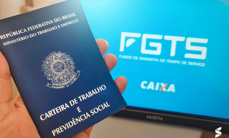 Carteira de trabalho sendo segurada com a tela de fundo mostrando o logo do FGTS e CAIXA