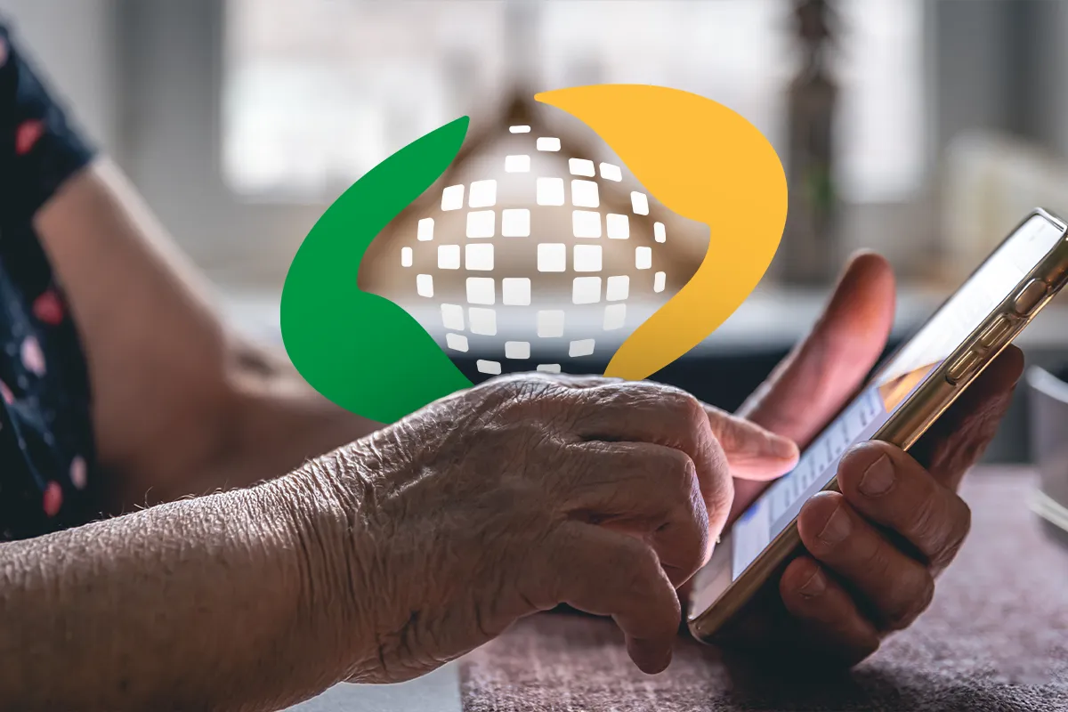 Pessoa idosa usando o celular para consultar informações sobre o INSS, simbolizando o processo de ressarcimento dos descontos indevidos.
