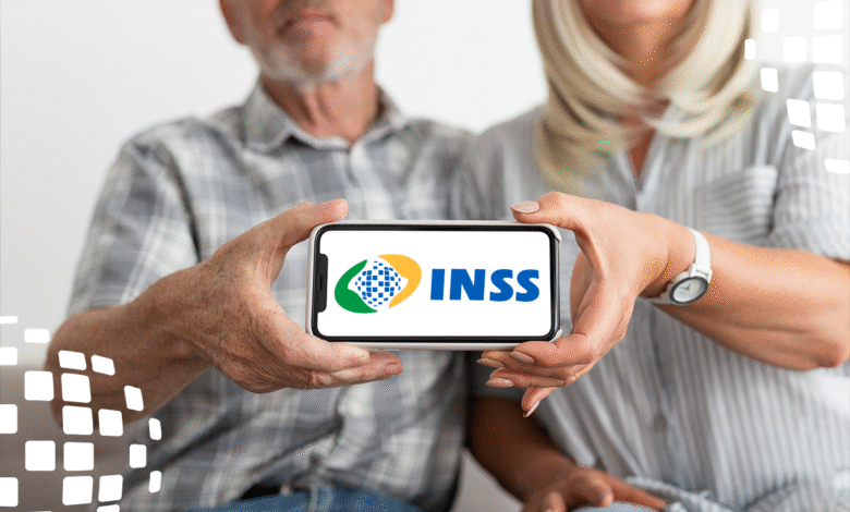 Casal idoso segurando smartphone com logo do INSS na tela