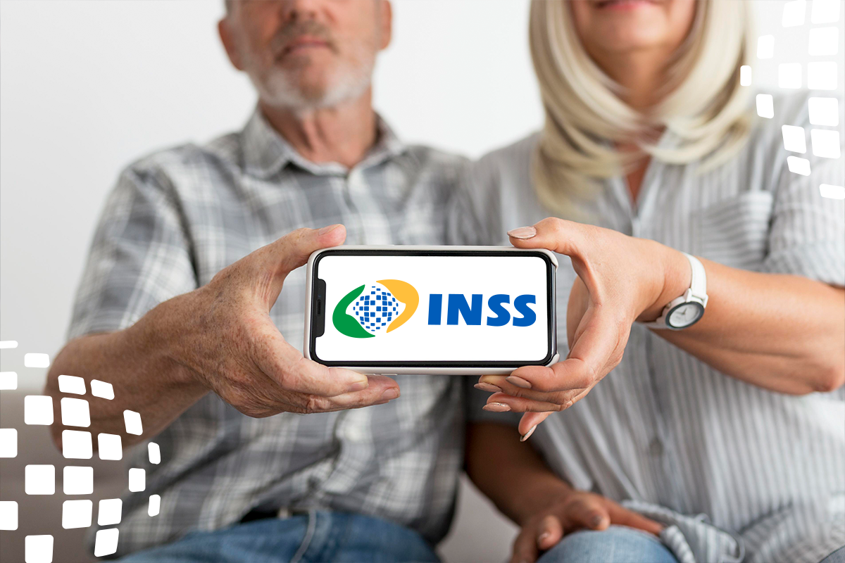 Casal idoso segurando smartphone com logo do INSS na tela
