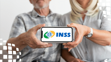 Casal de idosos segurando celular com logo do INSS na tela