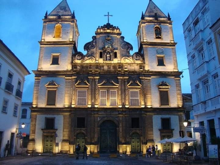 Igreja de São Francisco em Salvador iluminada à noite, com detalhes arquitetônicos barrocos.