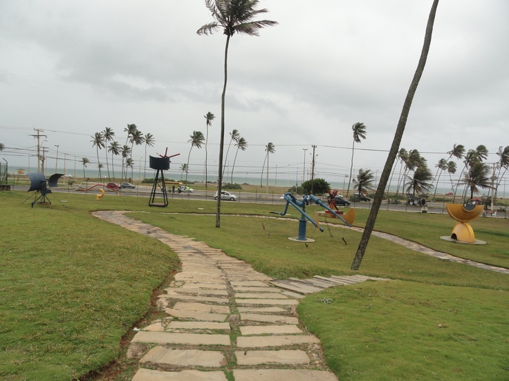 Trilha no Parque de Pituaçu, em Salvador, com esculturas interativas e vista para o mar.