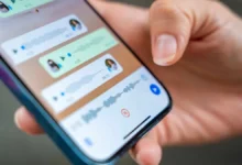 Pessoa segurando um smartphone com a tela do WhatsApp mostrando mensagens de voz