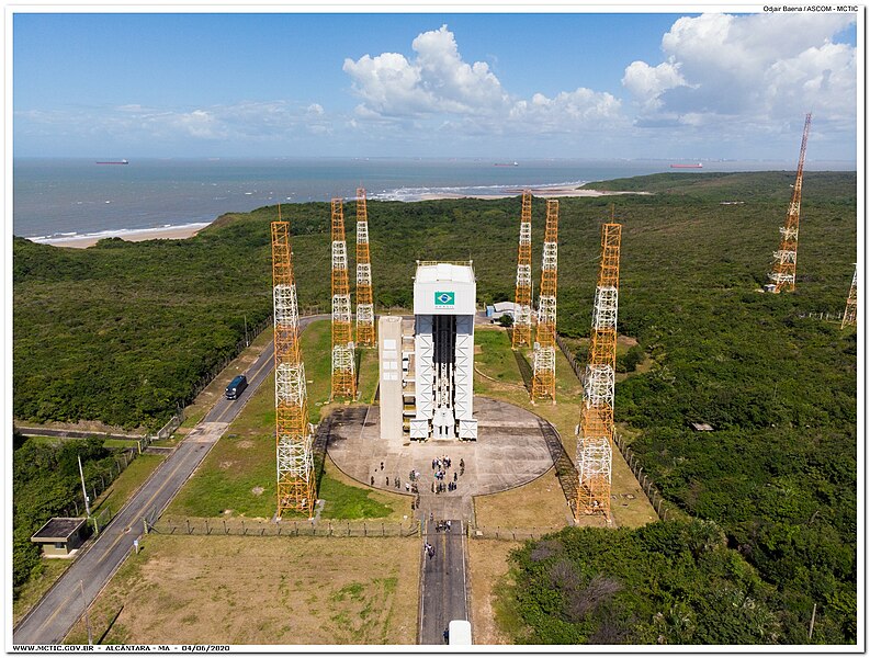 Vista aérea do Centro de Lançamento de Alcântara, com estrutura de foguetes e antenas, em frente ao oceano.