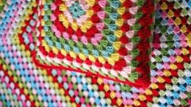 Almofadas e mantas coloridas feitas em crochê com pontos detalhados e texturizados.