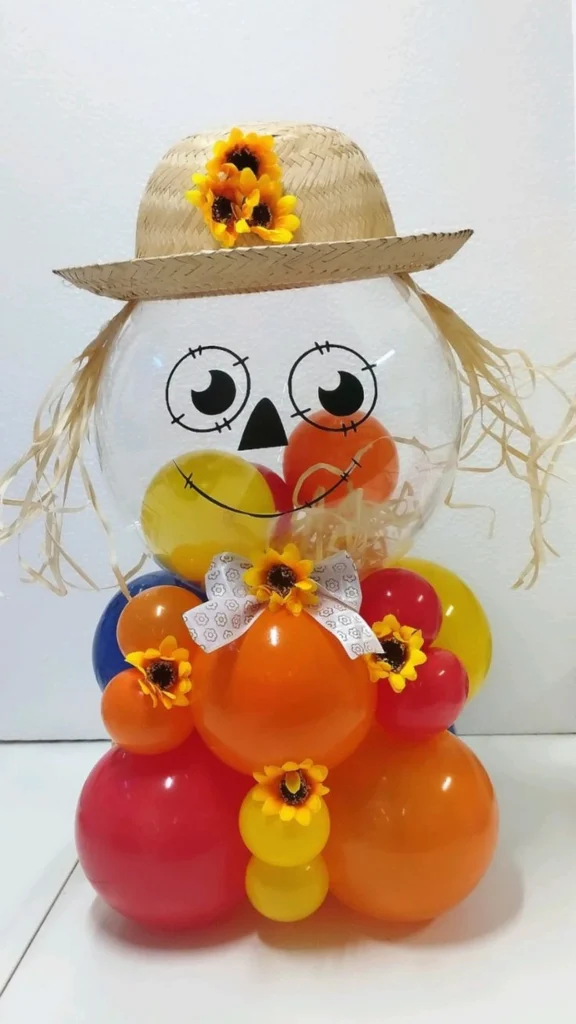 Arranjo colorido de balões com rosto de espantalho em balão transparente e chapéu de palha