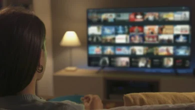 Mulher assiste a uma seleção de séries em uma plataforma de streaming na TV
