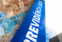 Notas de real brasileiro ao lado de um letreiro azul com a palavra "Previdência Social", representando o auxílio-acidente do INSS.