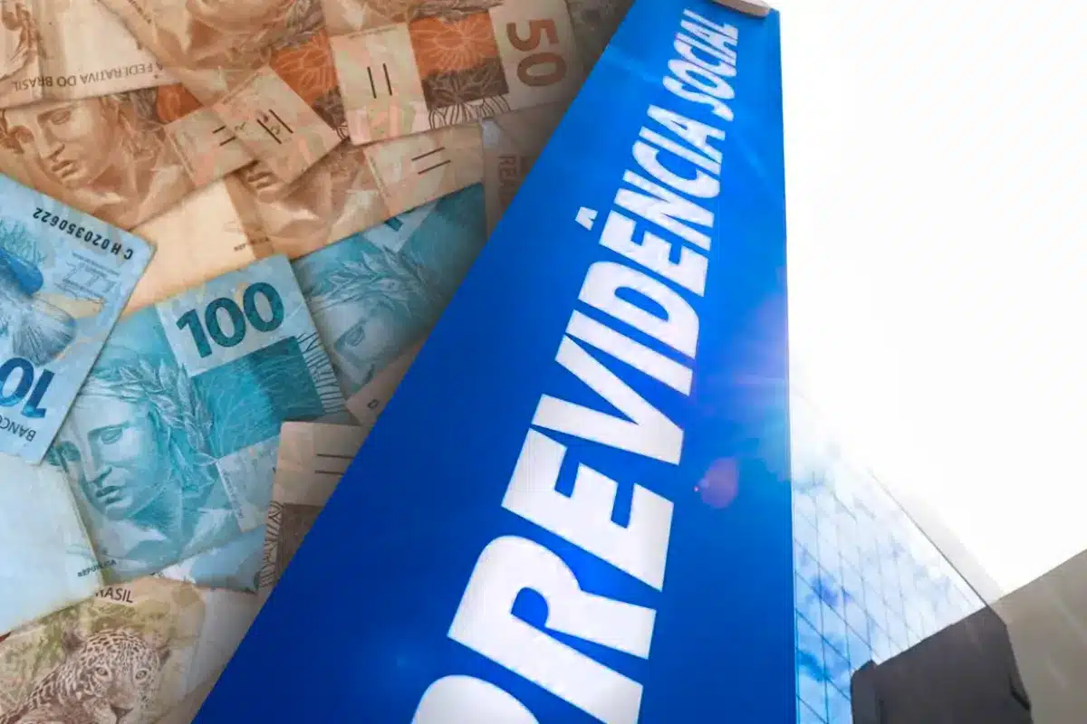 Notas de real brasileiro ao lado de um letreiro azul com a palavra "Previdência Social", representando o auxílio-acidente do INSS.