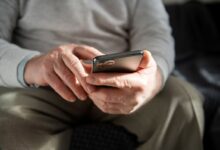 Mãos de idoso usando celular para aprender a fazer Pix