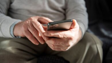Mãos de idoso usando celular para aprender a fazer Pix