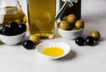Azeite de oliva sendo servido em prato branco, com azeitonas verdes e pretas ao fundo, ilustrando marcas proibidas de azeite no mercado.