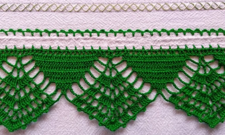 Barrado de crochĂȘ verde feito Ă mĂŁo para toalhas e panos de prato, exibindo detalhes delicados e padrĂŁo triangular.