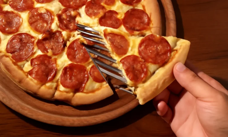 Pizza de pepperoni caseira sendo servida, com queijo derretido e crosta dourada.