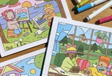 Livros de colorir Bobbie Goods com ilustrações de ursinhos em ambientes ao ar livre e internos, com marcadores coloridos ao redor.