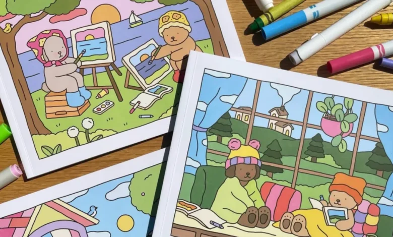 Livros de colorir Bobbie Goods com ilustrações de ursinhos em ambientes ao ar livre e internos, com marcadores coloridos ao redor.