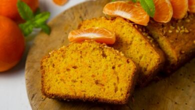 Fatias de bolo de fubá com laranja e pedaços de tangerina, decorado com folhas de hortelã.