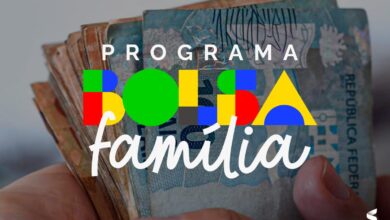 Família beneficiária do Bolsa Família sorrindo com notas de 100 reais.