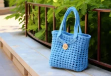 Bolsa de crochê azul com alças e botão de madeira, perfeita para complementar seu look fashion