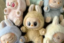 Bonecos fofos com roupinhas de pelúcia em diferentes cores e expressões variadas.