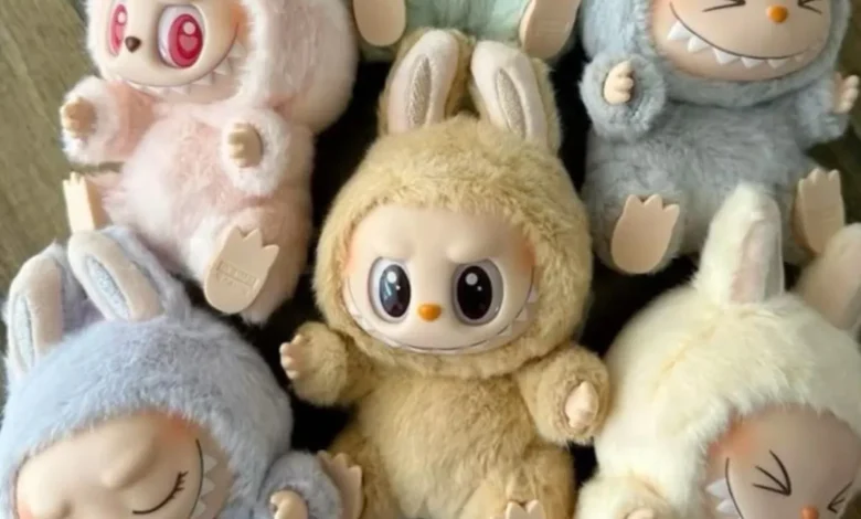 Bonecos fofos com roupinhas de pelúcia em diferentes cores e expressões variadas.