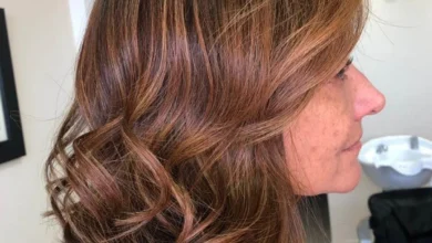 Cabelos iluminados em mulher madura com tons naturais de mel, caramelo e amêndoa, realçando a beleza aos 50+.